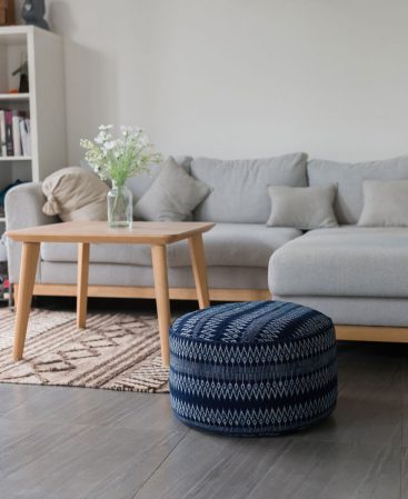 A blue and white pouffe cushion with a geometric design.