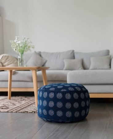 A boho floor pouf with indigo batik patterns and sun motifs.