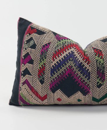 A colorful boho pillow cover made with ethnic textiles sourced from tribal communities.