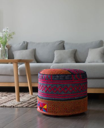 A colorful ethnic pouf cushion in a living room.