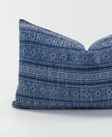 A cushion cover with a vintage blue and white design.