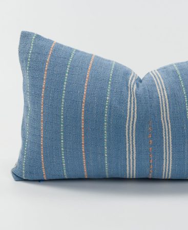 A light blue pillow cover with ethnic character.