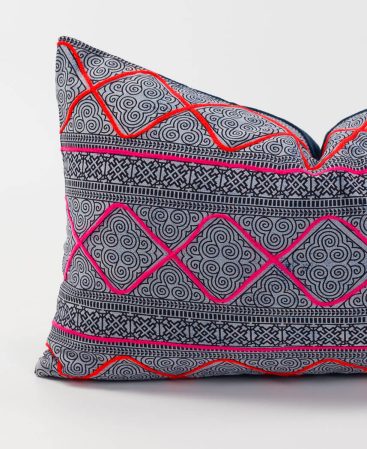 A lumbar pillow with hot pink and rich orange colors.