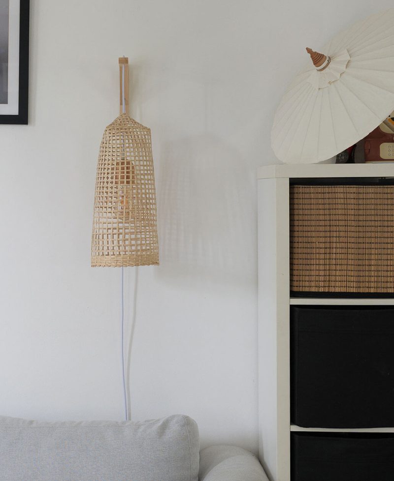 A natural wood wall lamp that plugs in and has a bohemian aesthetic.