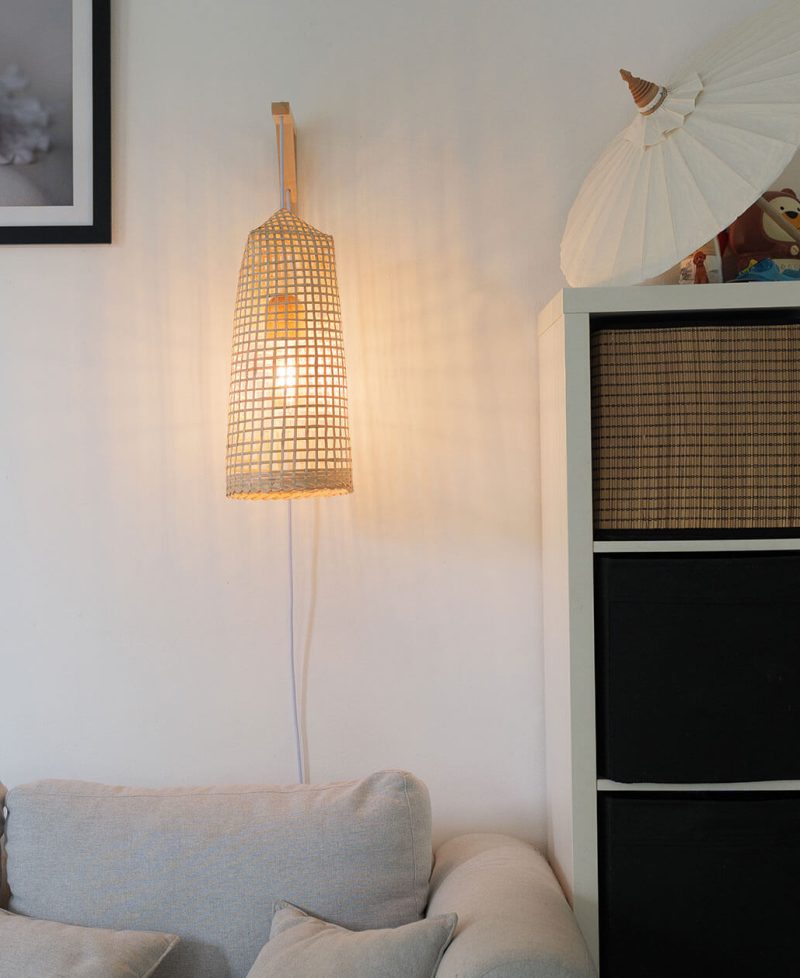 A plug-in rustic wood wall sconce in a living room mounted flush to the wall.