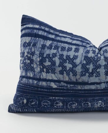 A purple lumber cushion with tons of ethnic style.