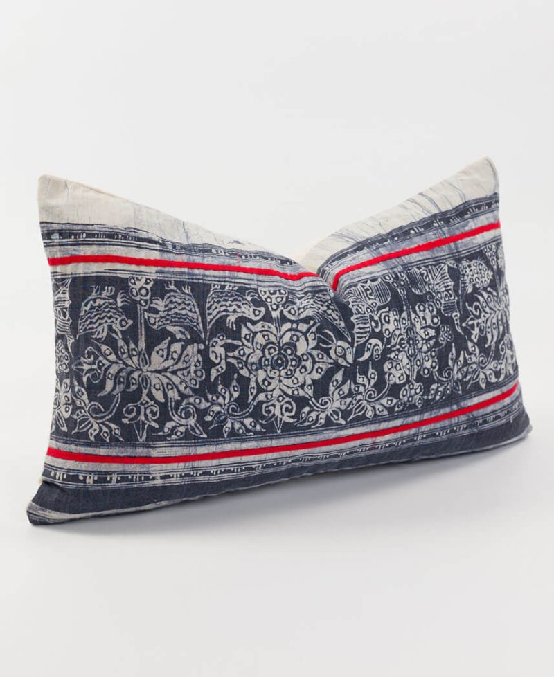 A red and gray cushion cover with ethnic style.