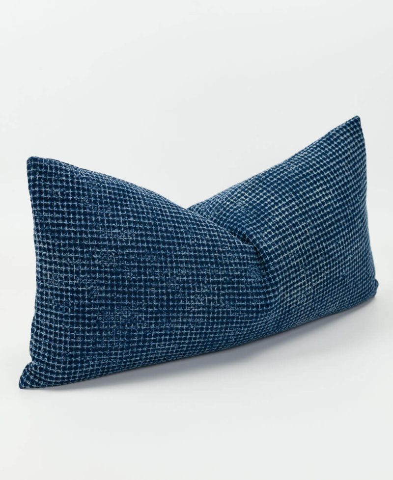 A stonewashed effect cushion cover in a dark navy tone.