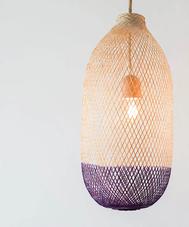 A tall wicker light shade that has been dyed purple.