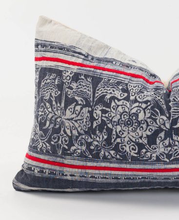 A unique ethnic cushion cover with red stripes and gray accents.