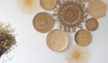 A variety of wood wall art pieces hanging on a wall.