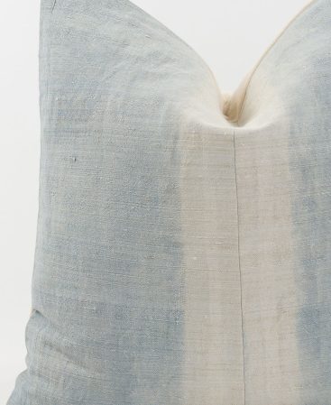 An ethnic hemp fabric cushion cover with faded colors.