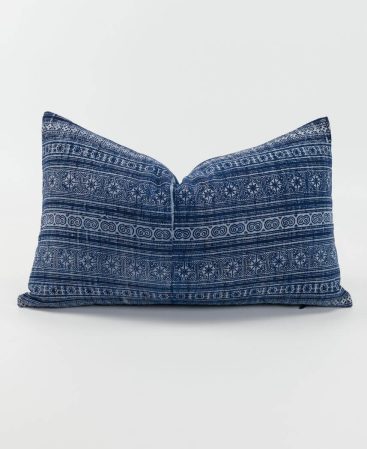 An indigo blue and white cushion with a willowware-inspired design.