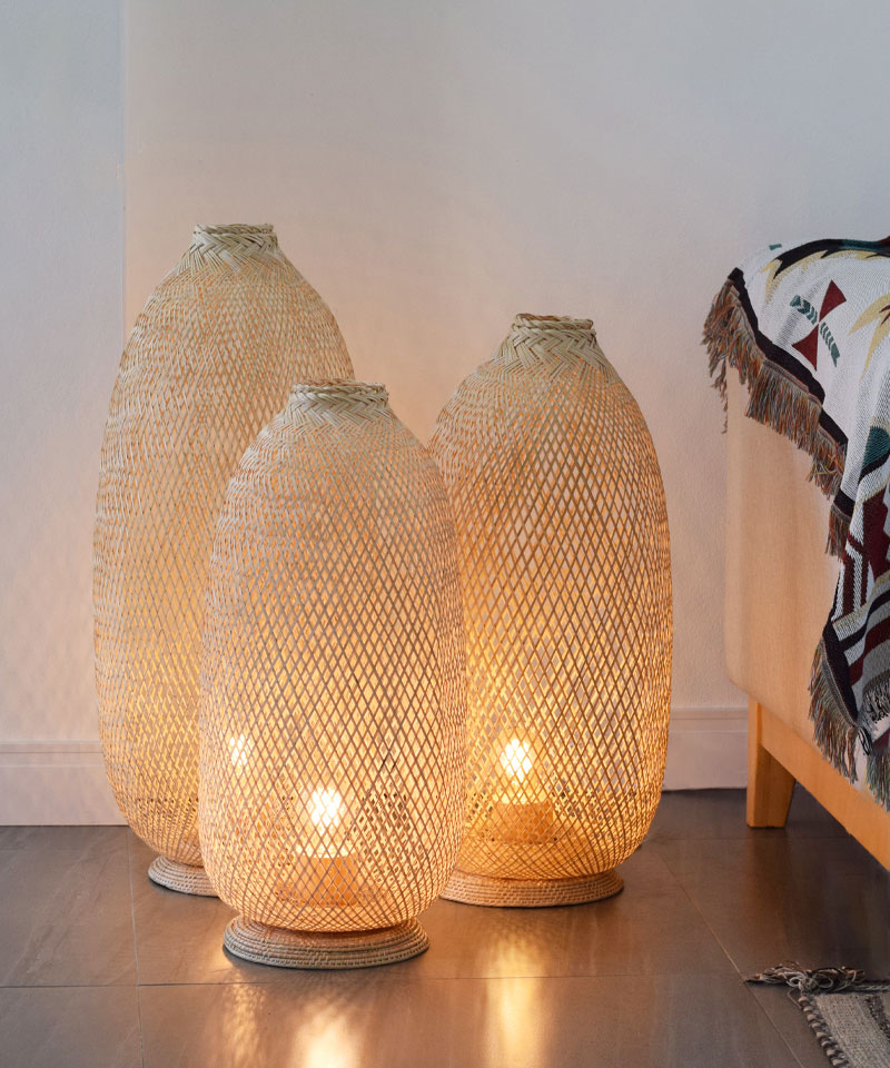 A bamboo rattan floor lamp set comprising of three tall standing lamps.