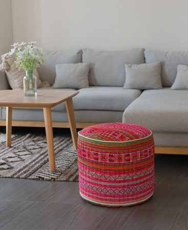 Bright pink and subtle cream tones help add some color to your room, shown here with this ottoman.