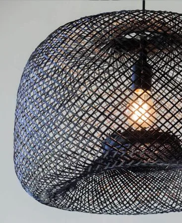 Close up photo of a dyed black light fixture made of woven bamboo wood.
