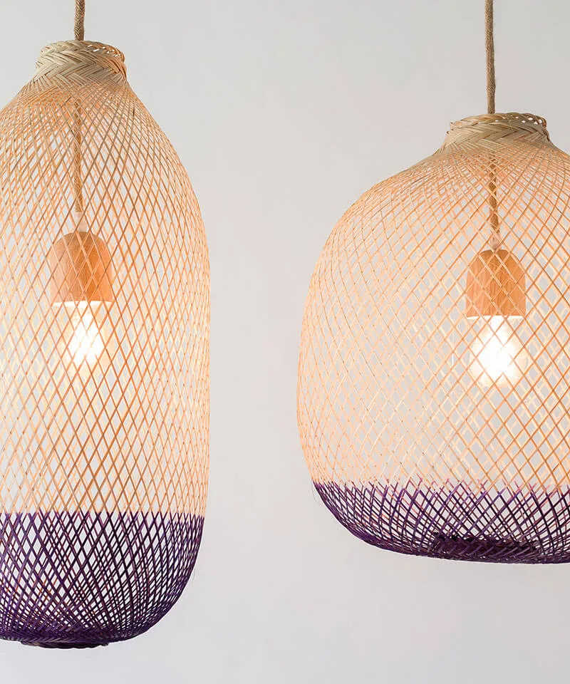 Close up view of two natural wood and dark purple light shades.