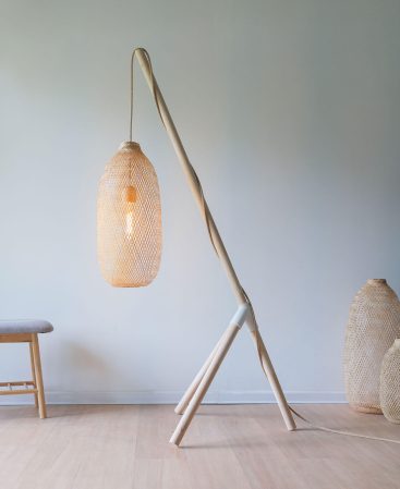 Japandi tripod floor lamp with woven bamboo shade styled in a minimalist living room