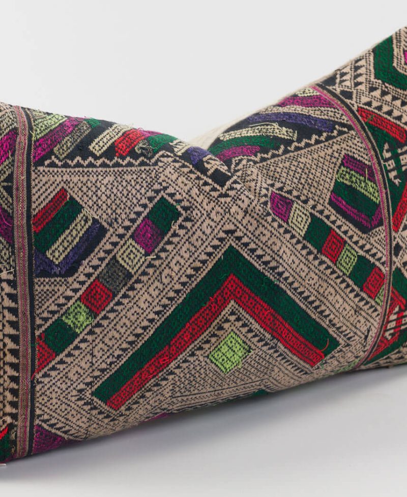 Red, green and brown colors make up the front of this pillow cover.