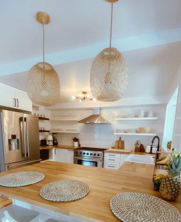 Round woven bamboo pendant lights over a wood kitchen island.