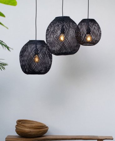Three round bamboo pendant lights in black color.