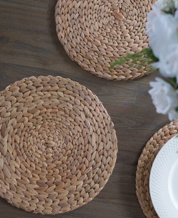Water hyacinth placemats on a brown wooden dining table.