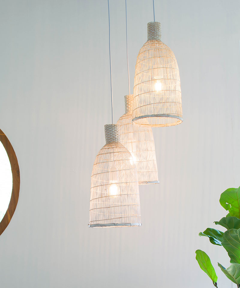 A trio of white pendant lights, elegantly hanging from a triple cluster canopy.