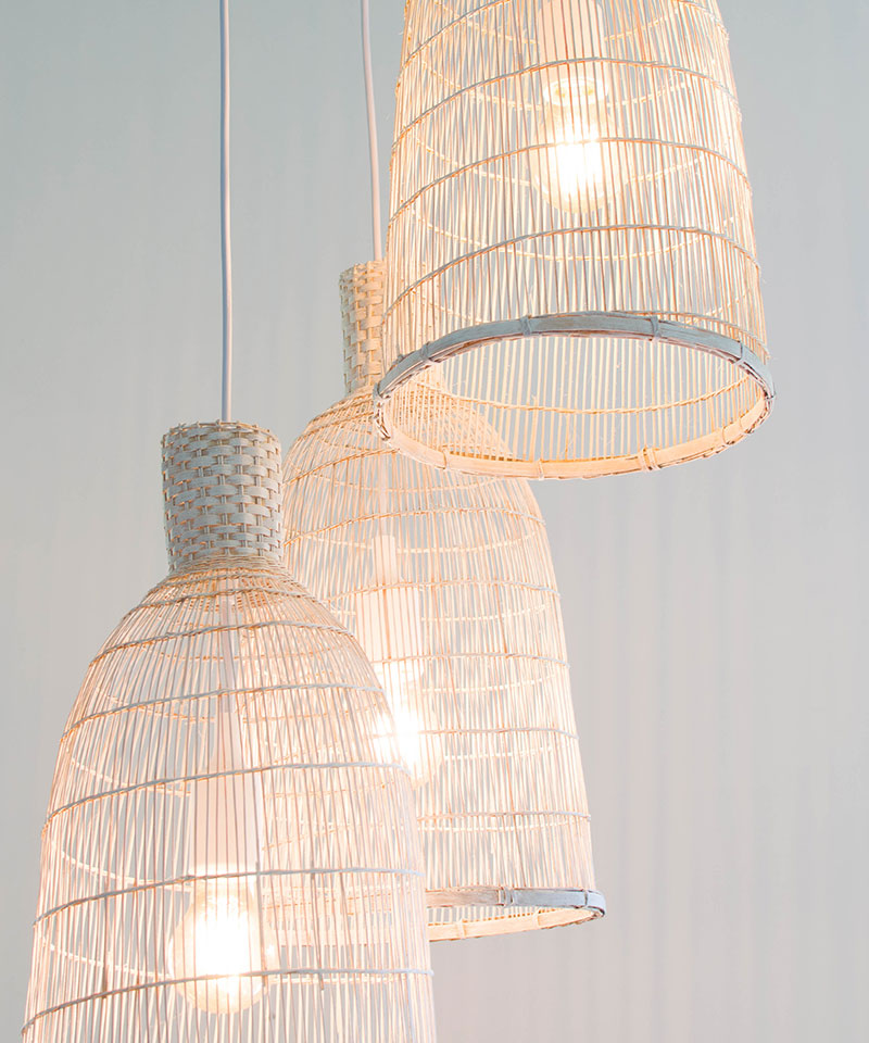 Close up view of three white pendant lights in a whitewashed style.
