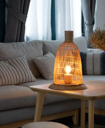 Small woven rattan table lamp with a warm bulb.